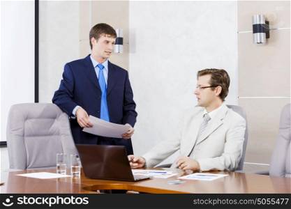 Young businessman in office showing documents to his boss. I&rsquo;ve prepared report