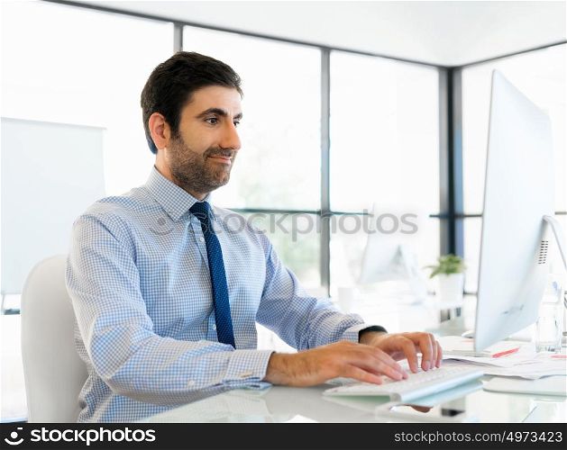 Young businessman in office sitting and smiling
