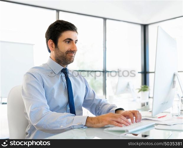 Young businessman in office sitting and smiling