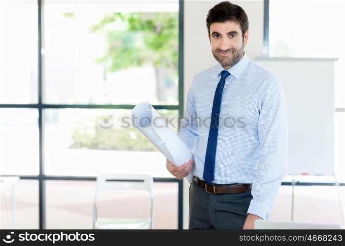 Young businessman in office standing with papers in his hands