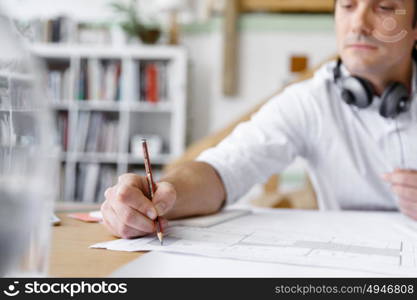 Young businessman in office. Young businessman working in office with headphones