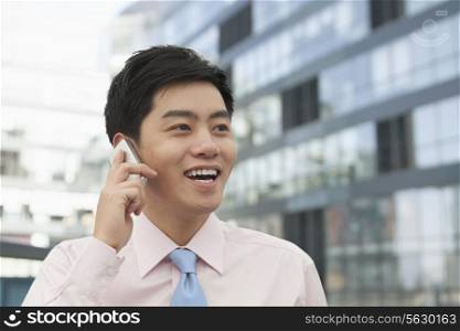 Young Businessman in pink button down shirt on the phone, Beijing, China