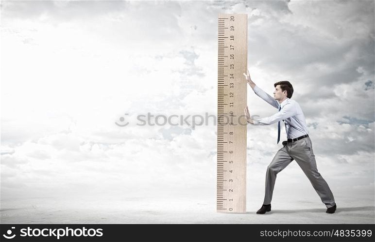 Young businessman in suit measuring ruler benefit. Man with scale