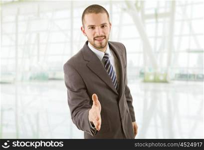 young businessman in suit offering to shake the hand at the office