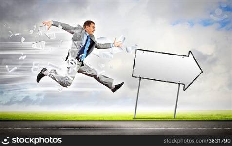 Young businessman in suit running on the road