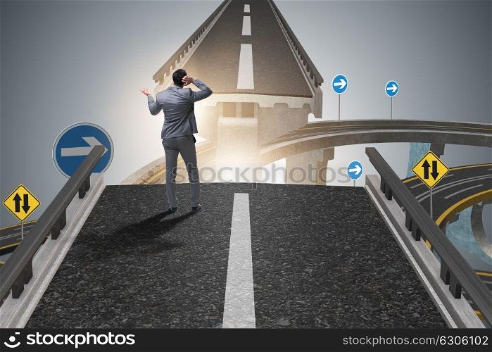 Young businessman in uncertainty concept with bridge