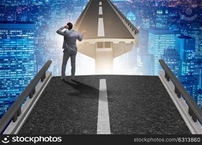 Young businessman in uncertainty concept with bridge