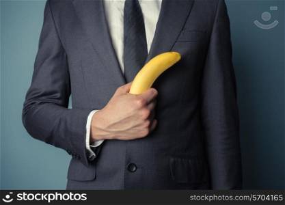 Young businessman is holding a banana