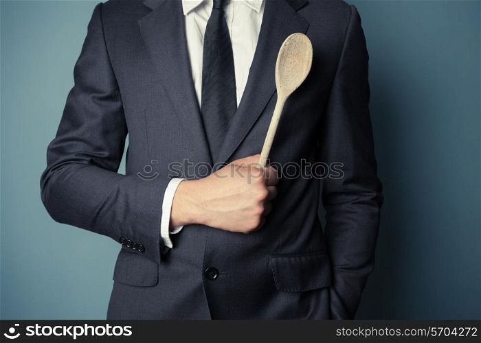 Young businessman is holding a wooden spoon