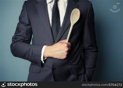 Young businessman is holding a wooden spoon