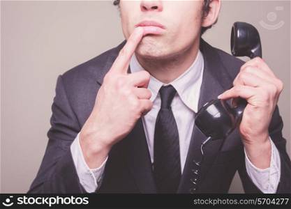 Young businessman is on the phone and is thinking about what to say