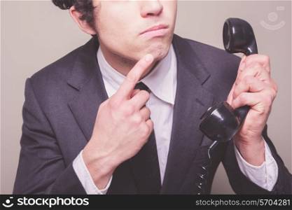Young businessman is on the phone and is thinking about what to say