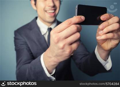 Young businessman is taking a selfie with his smart phone