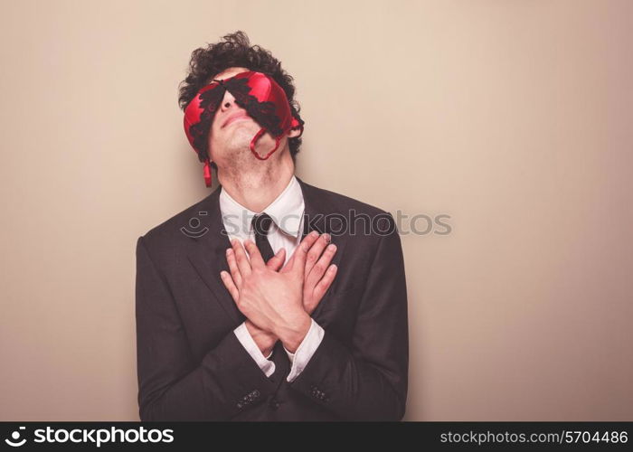 Young businessman is wearing a sexy bra on his face