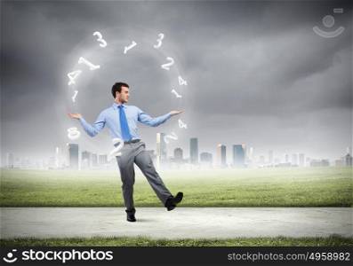 Young businessman juggling with numerals against city background. Businessman juggler