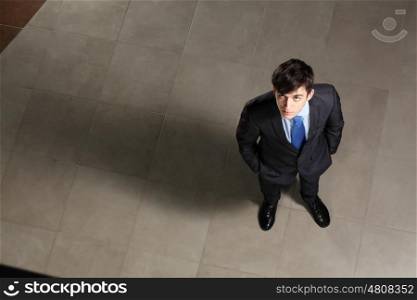 Young businessman looking above. Image of young businessman looking above. Top view