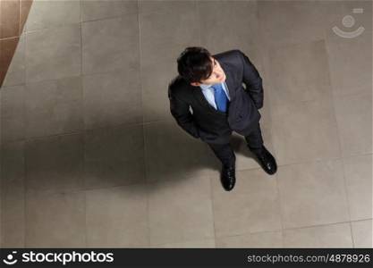 Young businessman looking above. Image of young businessman looking above. Top view