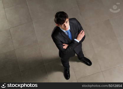 Young businessman looking above. Image of young businessman looking above. Top view