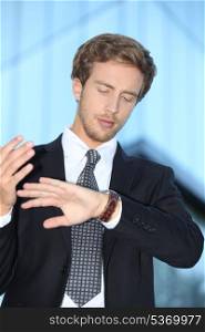 Young businessman looking at his watch