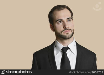 Young businessman looking away over colored background