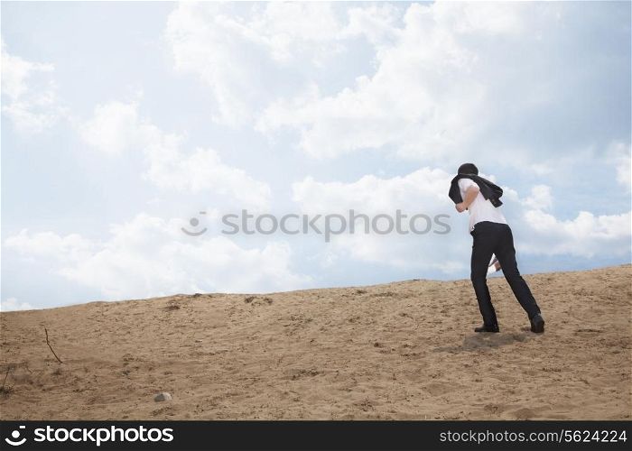 Young businessman lost and walking through the desert