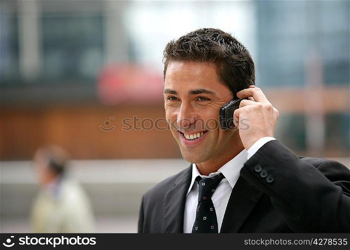 Young businessman making a call outside