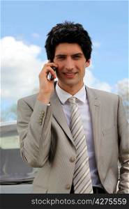 Young businessman making call from roadside