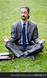 Young businessman meditating in the garden