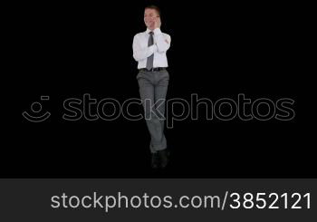 Young businessman on mobile and sitting, against black