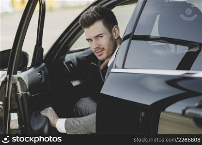 young businessman opening car door