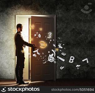 Young businessman opening door. Image of young businessman opening the door