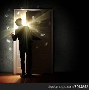 Young businessman opening door. Image of young businessman standing with back opening door against dollar sigh background