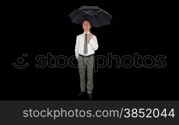 Young businessman opening umbrella, against black