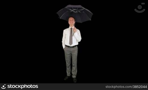 Young businessman opening umbrella, against black