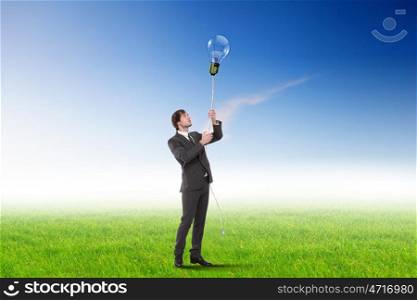 Young businessman outdoor with a bulb as a symbol of creative thinking
