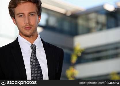Young businessman outside a modern office building