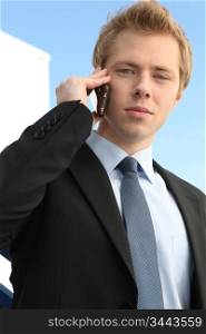 Young businessman outside building making call