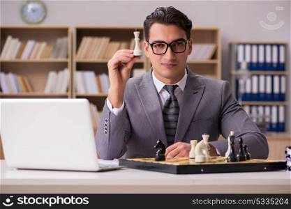 Young businessman playing chess in the office