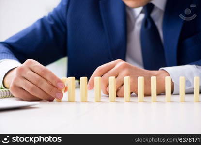 Young businessman playing with domino in office