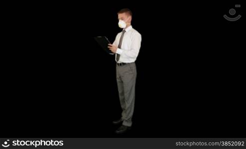 Young businessman, protective glasses and mask taking notes, against black