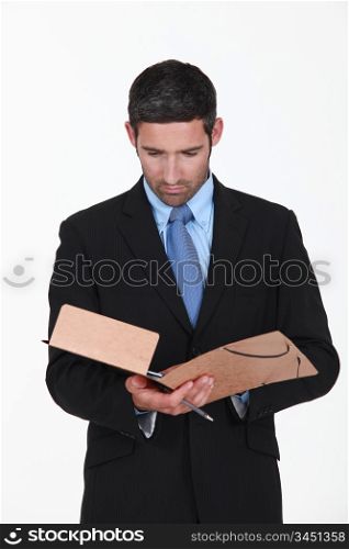 Young businessman reading contents of folder