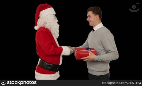 Young Businessman receiving a present from Santa Claus, shaking hands, against black