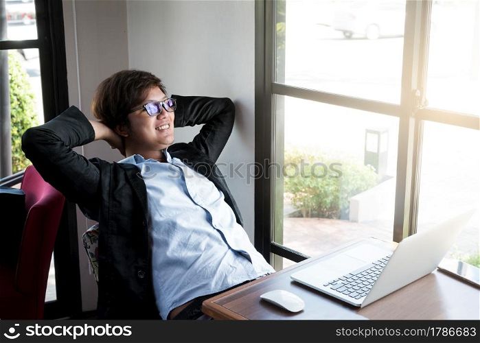 Young businessman relaxing at his desk in coffee shop,Relax,Success