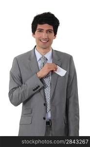 Young businessman removing business-card from pocket