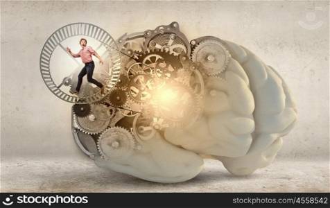 Young businessman running in wheel of gears mechanism. Always busy at work