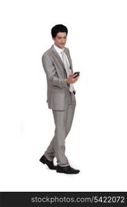 Young businessman sending text message whilst walking