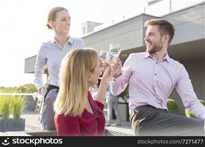 Young businessman shaking hands with mature businesswoman during rooftop party