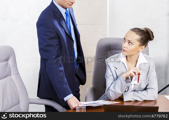 Young businessman showing lady boss business documents. Office work moments