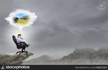 Young businessman sitting in chair and dreaming about something. A five minute break