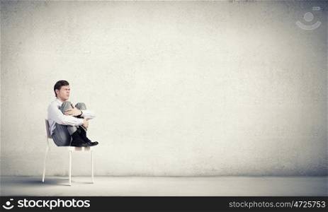 Young businessman sitting in chair and relaxing